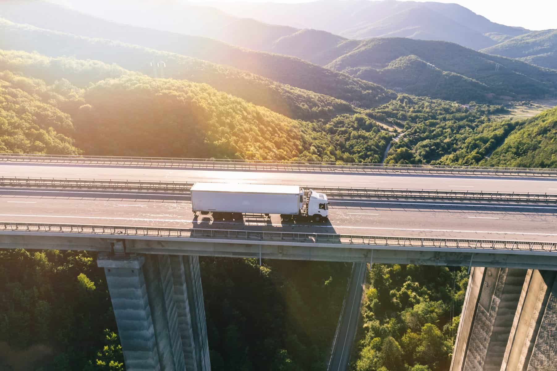 Truck driving on elevated highway through mountains