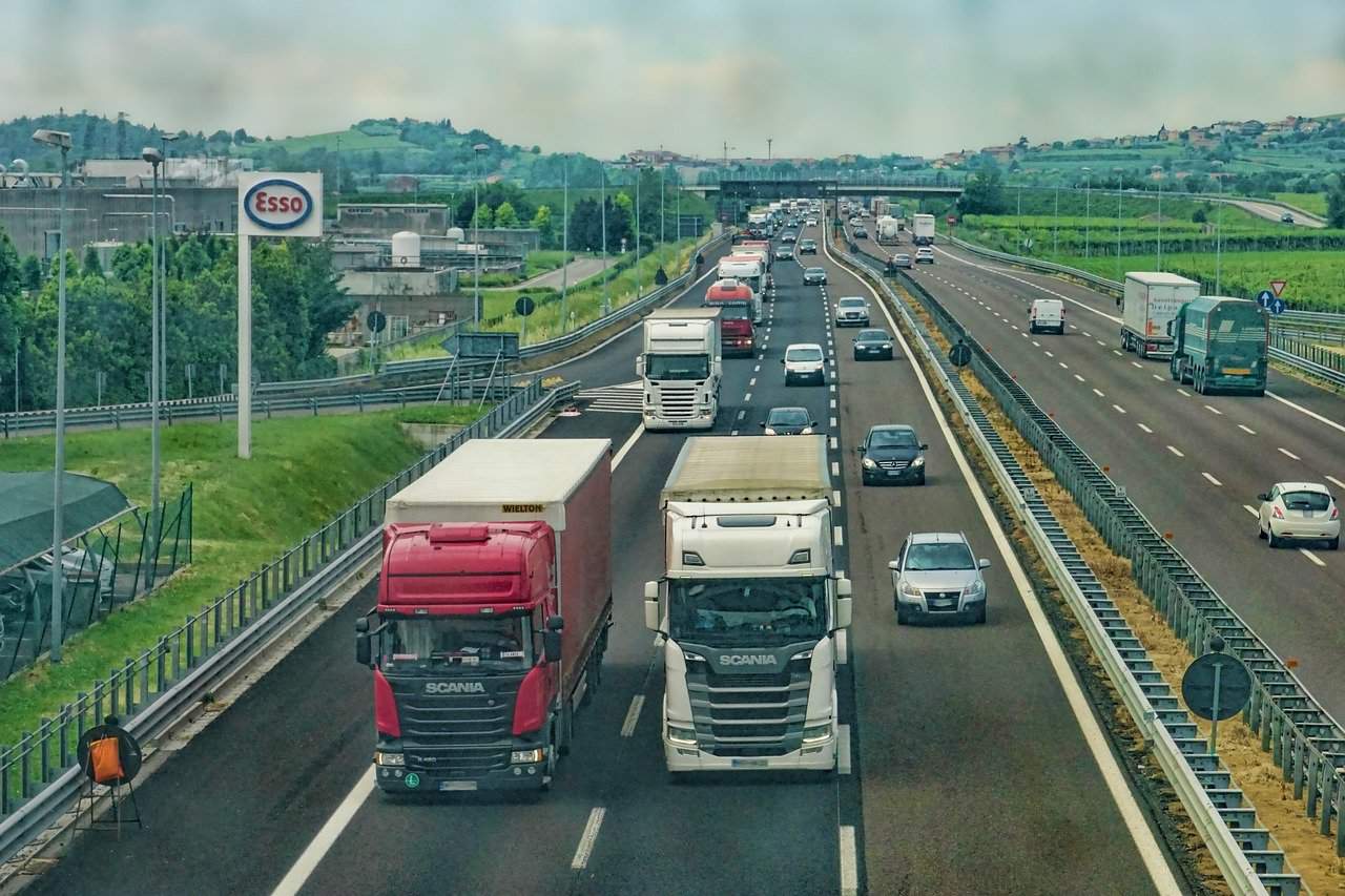 Busy highway with trucks and cars driving.