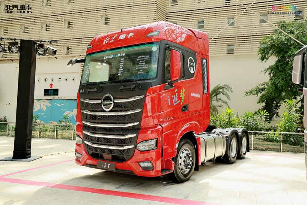 Red BAIC heavy-duty truck on display indoors.