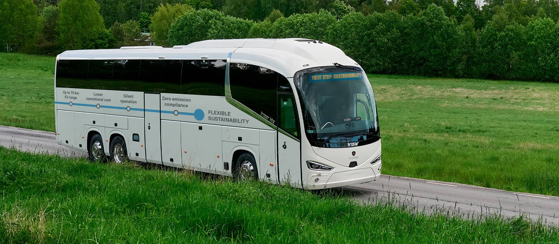 Electric bus driving through green countryside
