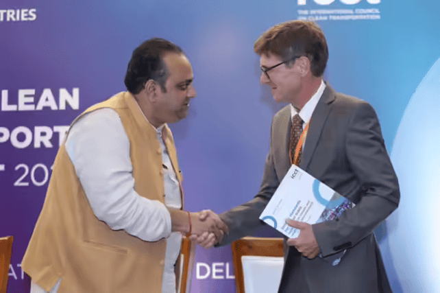 Two men shaking hands at a conference event.